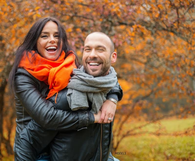 Attractive couple smiling together in the fall.