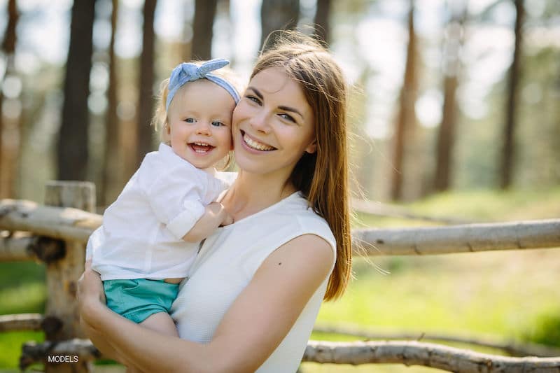 Woman holding her young daughter.